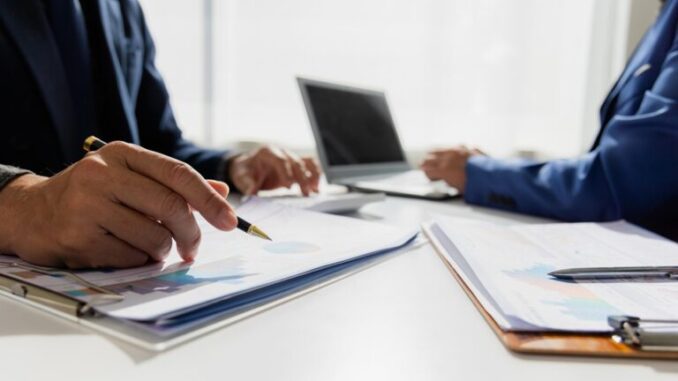 Close,Up,Of,Asian,Male,Company,Executives,Working,Together,Reviewing
